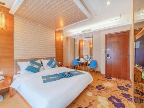 a bedroom with a large white bed and a table at Lijiang Waika Hotel in Lijiang