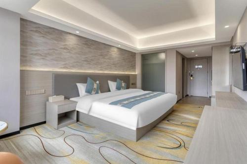 a large bedroom with a large bed and a television at Lijiang Waika Hotel in Lijiang
