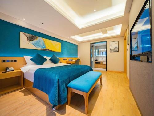 a bedroom with a large bed with a blue wall at Xian Katie Eastman Hotel in Xi'an