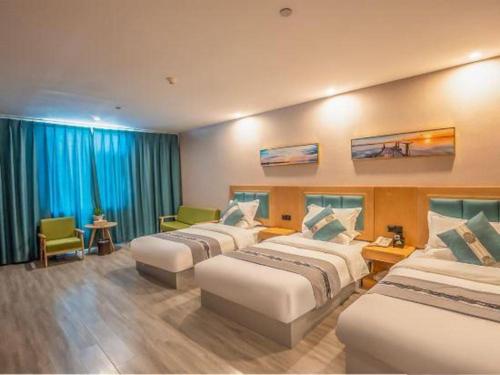a hotel room with three beds in a room at Lijiang Waika Hotel in Lijiang