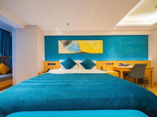 a blue bedroom with a large bed and a desk at Xian Katie Eastman Hotel in Xi'an