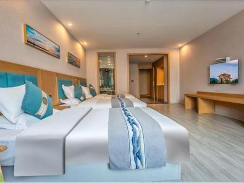 a large white bed in a large room at Lijiang Waika Hotel in Lijiang