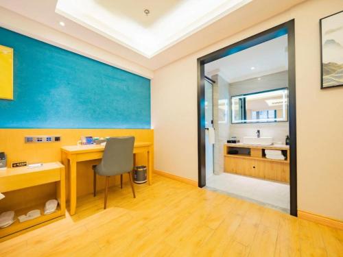 a room with a desk and a bathroom with a sink at Xian Katie Eastman Hotel in Xi'an