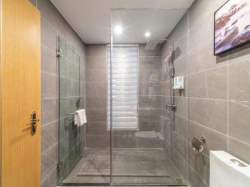 a bathroom with a shower with a glass door at Lijiang Waika Hotel in Lijiang