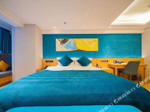a blue bedroom with a large bed and a desk at Xian Katie Eastman Hotel in Xi'an