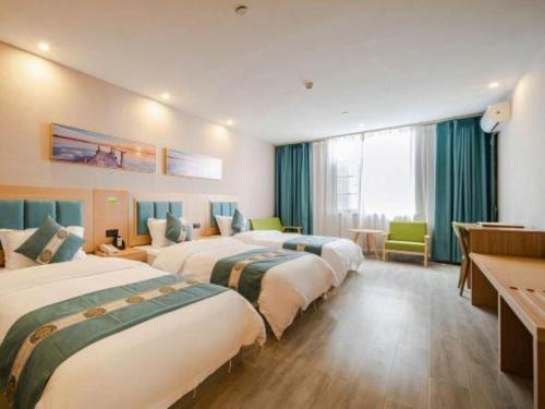 a hotel room with four beds in a row at Lijiang Waika Hotel in Lijiang