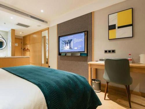 a bedroom with a bed and a desk and a television at Xian Katie Eastman Hotel in Xi'an