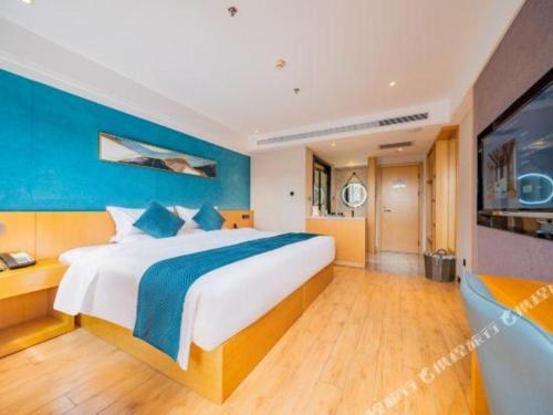 a bedroom with a large bed with a blue wall at Xian Katie Eastman Hotel in Xi'an