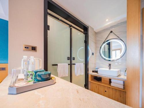 a bathroom with a sink and a mirror at Xian Katie Eastman Hotel in Xi'an