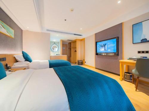 a bedroom with a large bed and a tv at Xian Katie Eastman Hotel in Xi'an