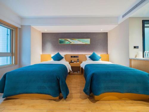 two beds in a room with blue and white at Xian Katie Eastman Hotel in Xi'an