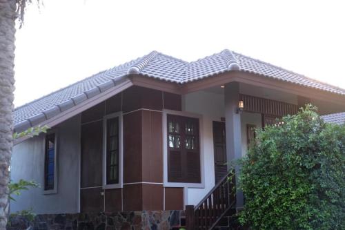 a brown and white house with a porch at Tong Hotel in Maha Sarakham