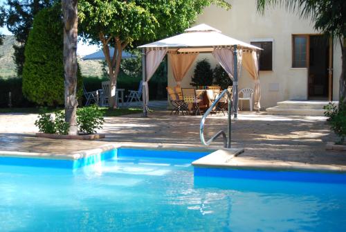 a swimming pool with an umbrella next to a house at Zena Holiday Villa in Pissouri