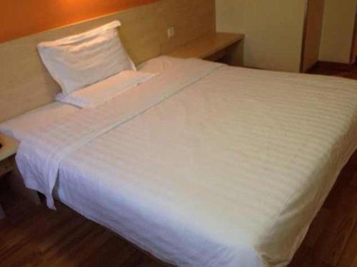 a large white bed in a hotel room at 7 Days Inn Nanjing Gaochun Metro Station in Gaochun