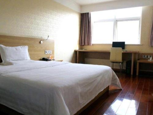 a bedroom with a large white bed and a desk at 7 Days Inn Nanjing Gaochun Metro Station in Gaochun