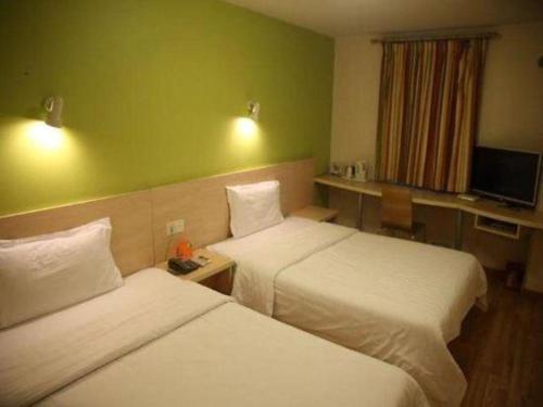 a hotel room with two beds and a television at 7 Days Inn Nanjing Gaochun Metro Station in Gaochun