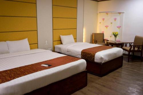 a hotel room with two beds and a table at Horizon Hotel in Olongapo