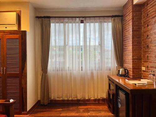 a living room with a large window with curtains at Mango Valley Hotel in Olongapo
