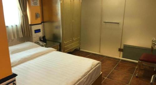 a bedroom with a white bed and a door at Happy Family Hotel in Macau