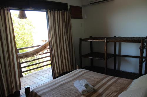 a bedroom with a bed and a balcony with a window at Apart Hotel Casa Grande in Natal