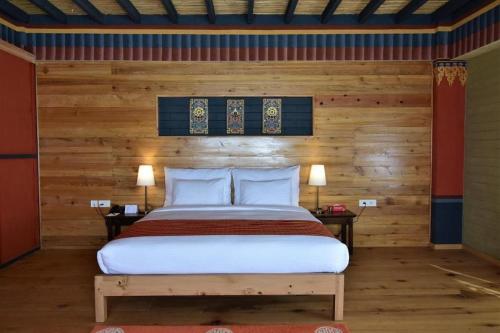 a bedroom with a bed and two nightstands and two lamps at Hotel Valley Thimphu in Thimphu