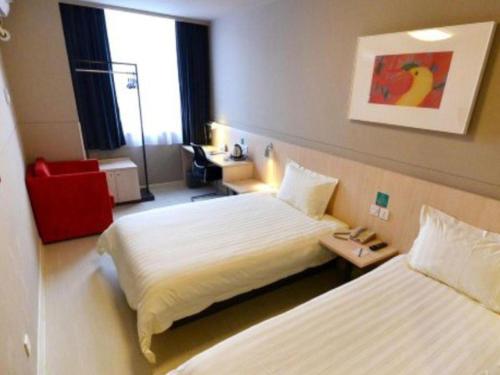 a hotel room with two beds and a window at Jinjiang Inn Wuhan Zhonghua Road HuangheLou Branch in Wuhan
