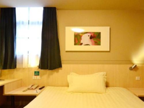 a bedroom with a bed and a table and a window at Jinjiang Inn Wuhan Zhonghua Road HuangheLou Branch in Wuhan