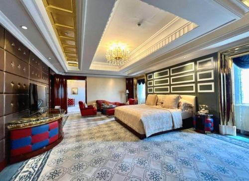a large bedroom with a bed and a living room at Tongxiang Inspirock Hotel in Jiaxing