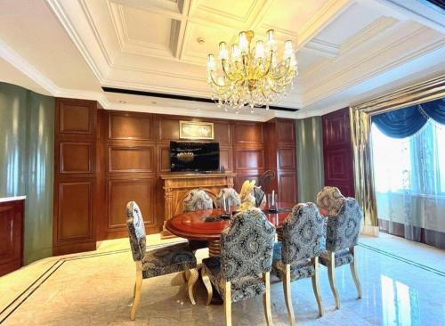 a dining room with a table and chairs and a chandelier at Tongxiang Inspirock Hotel in Jiaxing
