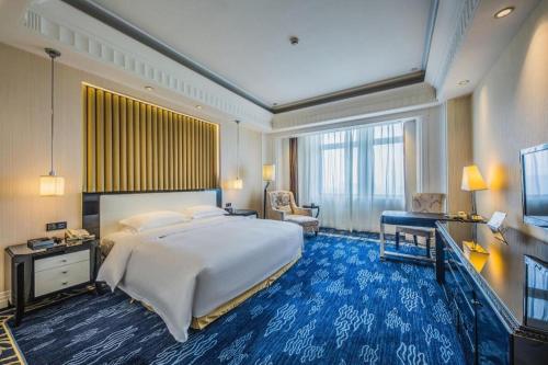 a large bedroom with a large bed and a desk at Tongxiang Inspirock Hotel in Jiaxing