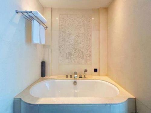 a bath tub in a bathroom with a wall at Tongxiang Inspirock Hotel in Jiaxing
