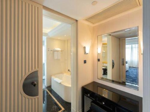 a bathroom with a large mirror and a sink at Tongxiang Inspirock Hotel in Jiaxing