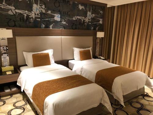 a hotel room with two beds in a room at Jai Alai Hotel in Macau
