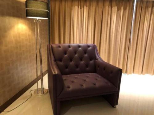 a chair in a room with a floor lamp and a lamp at Jai Alai Hotel in Macau