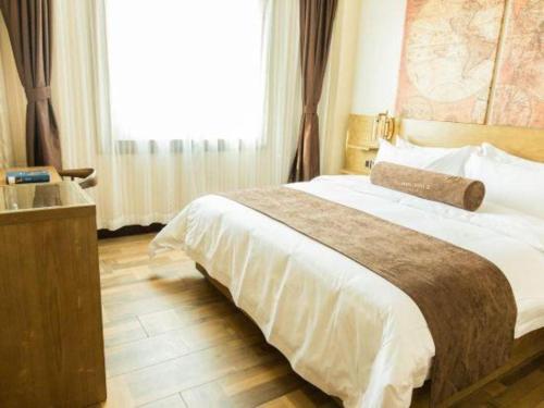 a hotel room with a large bed and a sink at James Joyce Coffetel Baoding Railway Station in Baoding