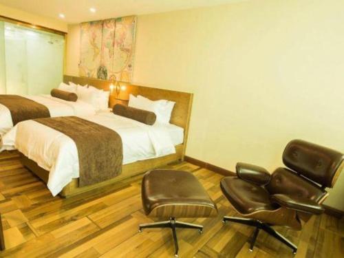 a hotel room with two beds and two chairs at James Joyce Coffetel Baoding Railway Station in Baoding