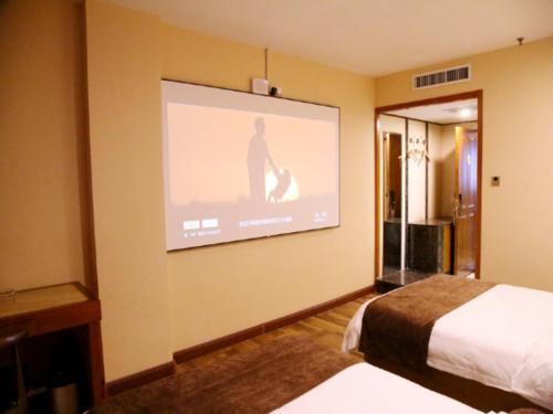 a hotel room with a projection screen on the wall at James Joyce Coffetel Baoding Railway Station in Baoding