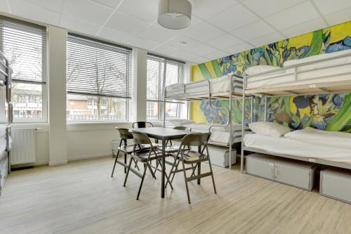 a living room filled with furniture and a large window at Dutchies Hostel in Amsterdam