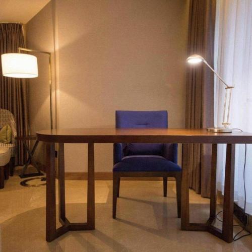 a wooden table with a blue chair and a lamp at James Joyce Coffetel Chengdu Jichang Road Shenxianshu in Chengdu