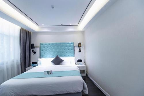 a bedroom with a large bed with a blue headboard at Xana Hotelle Xi'an GONG IP South Gate of Zhonglou in Xi'an