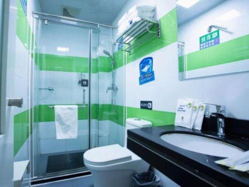 a green and white bathroom with a toilet and a sink at 7 Days Inn Tianjin Binhai Passenger Station Huabei Ceramics in Binhai