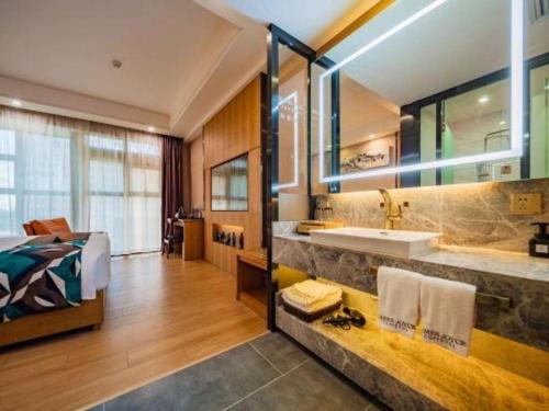a bathroom with a sink and a bed in a room at James Joyce Coffetel Xi'an Laochenggen Hongmiaopo Metro Station in Xi'an