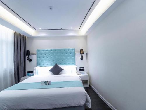 a bedroom with a large bed with a blue headboard at Xana Hotelle Xi'an GONG IP South Gate of Zhonglou in Xi'an