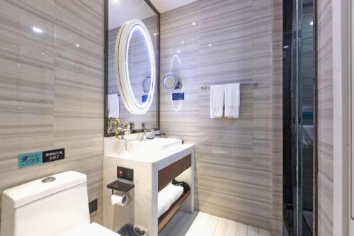 a bathroom with a sink and a toilet and a mirror at Xana Hotelle Xi'an GONG IP South Gate of Zhonglou in Xi'an