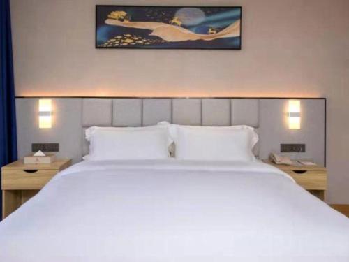 a large white bed in a hotel room at danfeng kelly hotel in Shenzhen