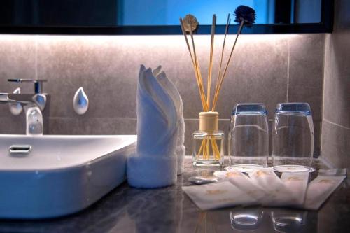 a bathroom counter with a sink and perfume bottles at danfeng kelly hotel in Shenzhen