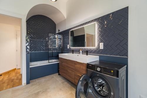 a bathroom with a washing machine and a sink at Hôtel Lefort - L'Oasis Urbaine in Guingamp