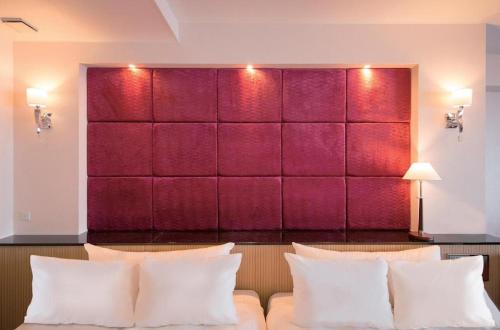 a room with a red wall with white pillows at HOTEL FUTARI KOMOREBI in Atami