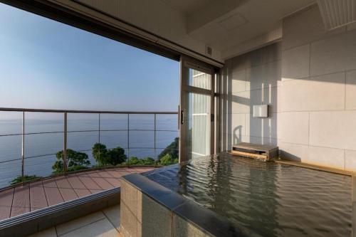 a swimming pool in a building with a view of the ocean at HOTEL FUTARI KOMOREBI in Atami