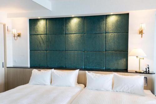 a bedroom with a green padded wall behind a bed at HOTEL FUTARI KOMOREBI in Atami
